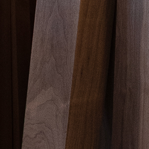 Dark walnut boards stacked on edge with the grain showing